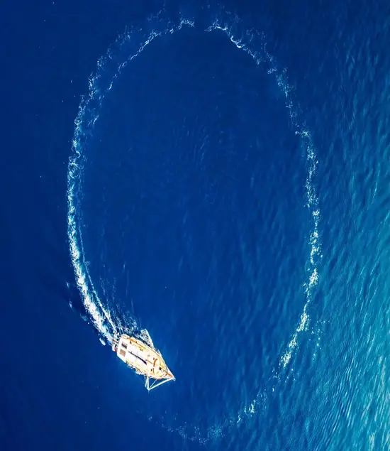 A luxury yacht creating a perfect circle in Bodrum's deep blue sea, signifying the perfect yacht charter experience that awaits you.